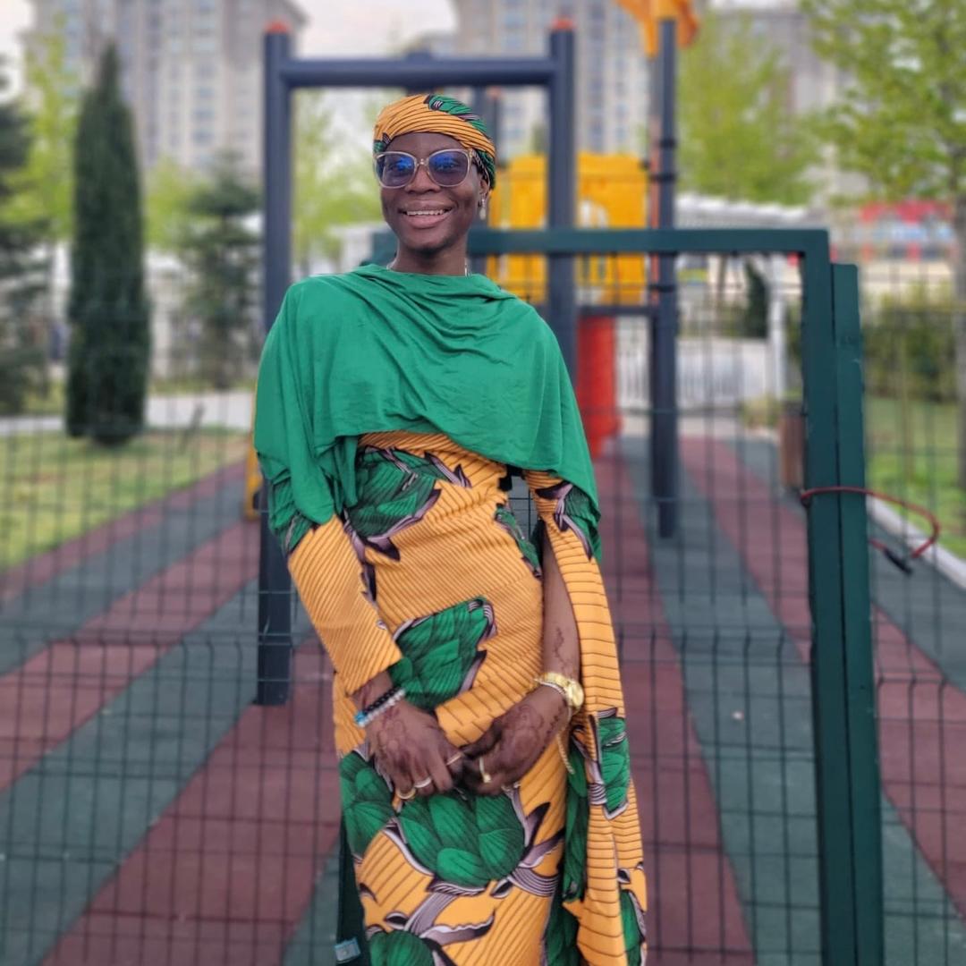 Azizah posing near a tree