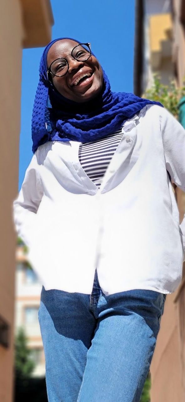 Azizah wearing white top and jeans